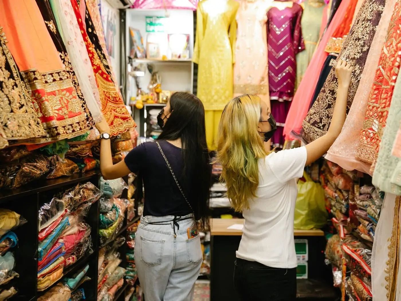 Young woman browsing a boutique's online collection on her phone inside a metro coach