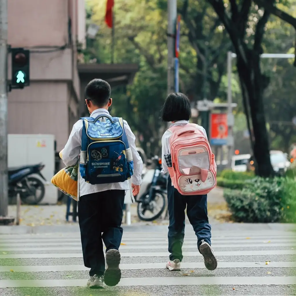 Children crossing a road near a school bus stop