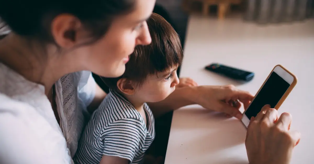 Parent checking a phone with her child
