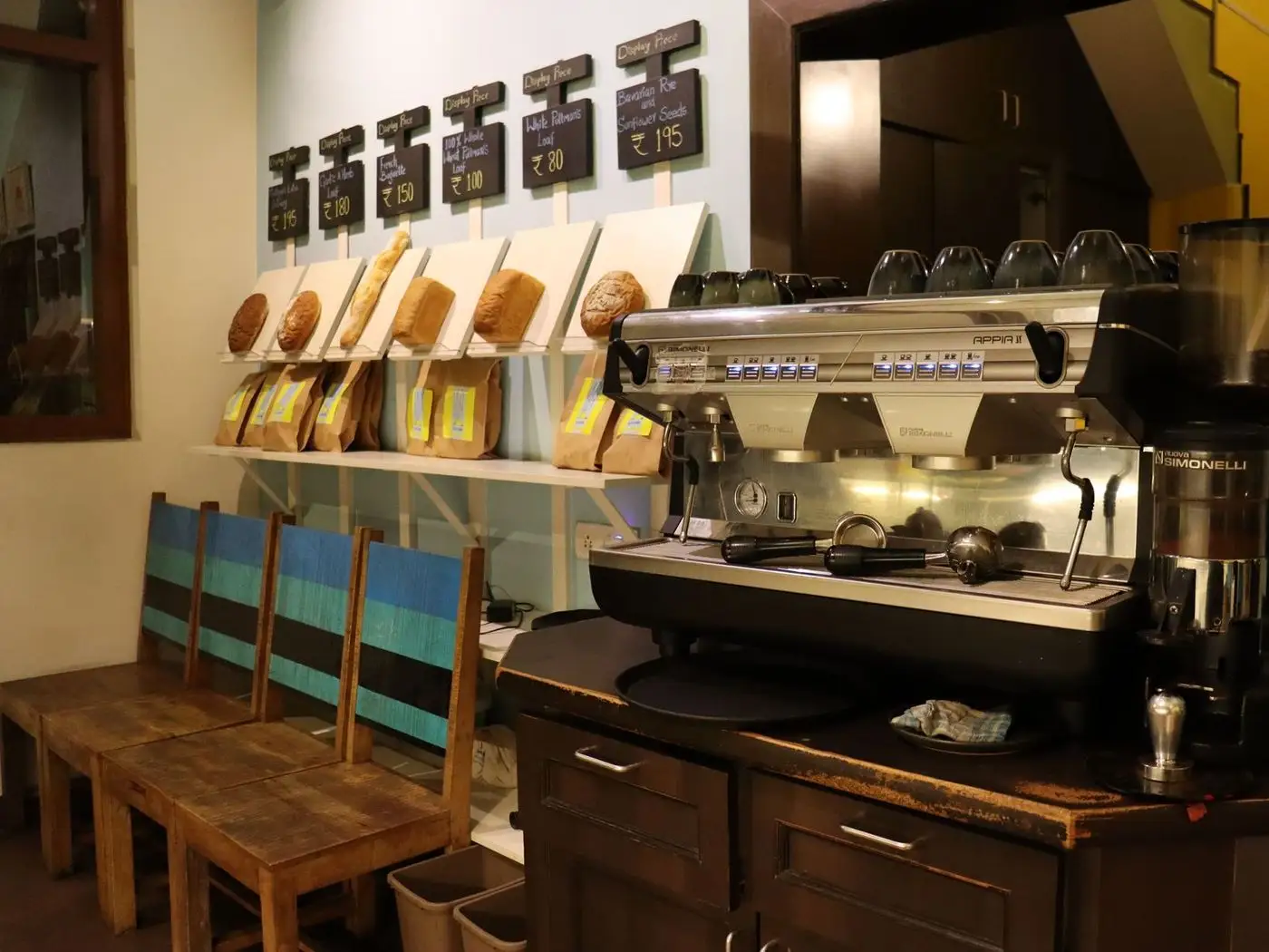 Phone on a cafe table showing a cafe website menu page with coffee photos and a WhatsApp order button