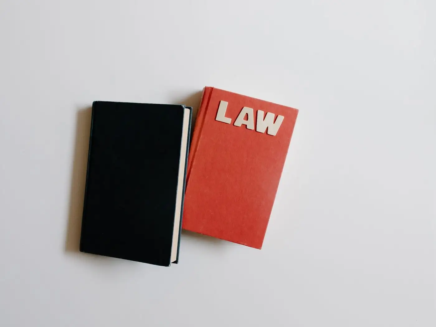 Quiet advocate's chamber desk with law books and a laptop showing a plain profile page with enrolment details